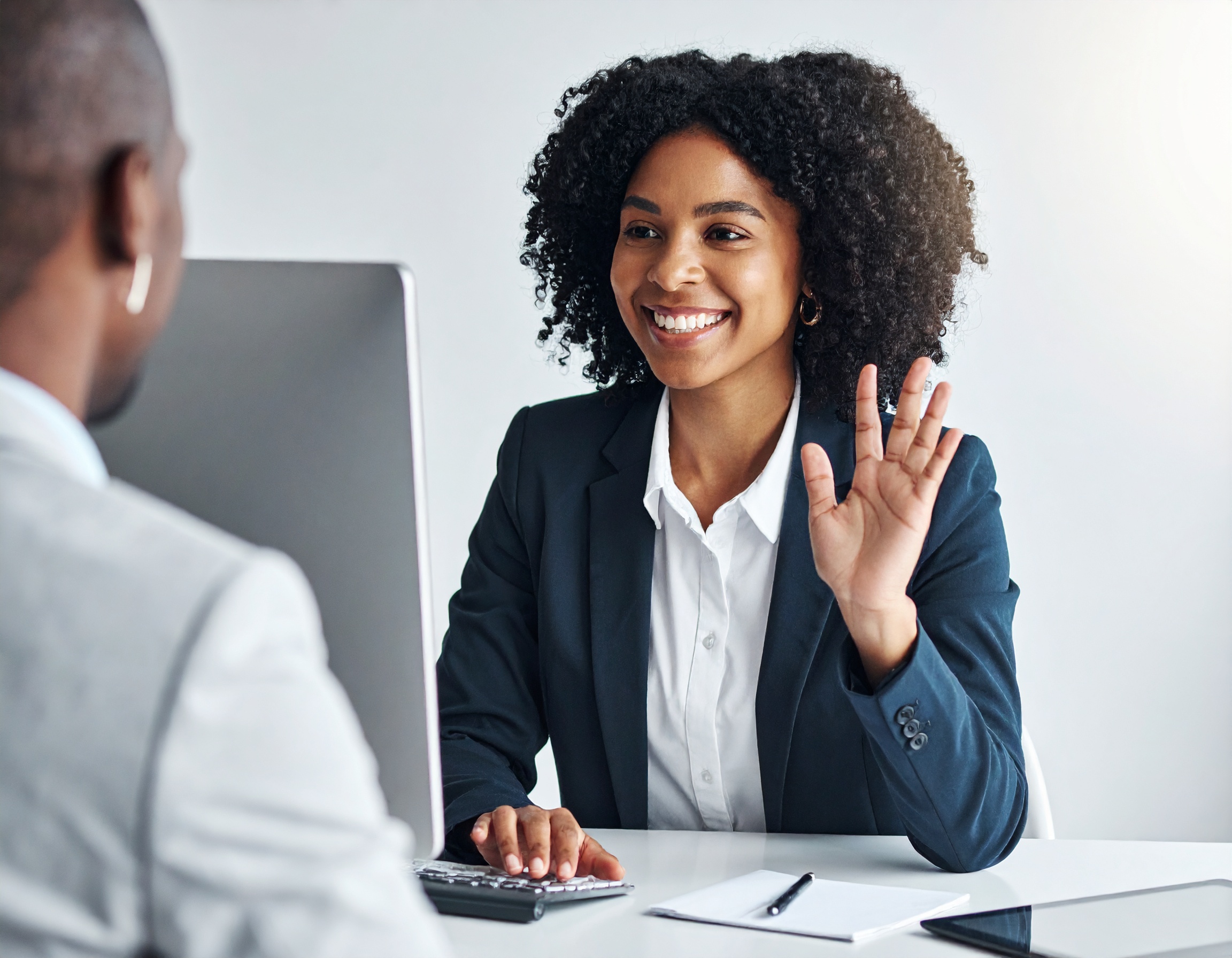Firefly_une jeune femme noire qui souris, assise a un bureau avec son ordi entraind e parler 20323